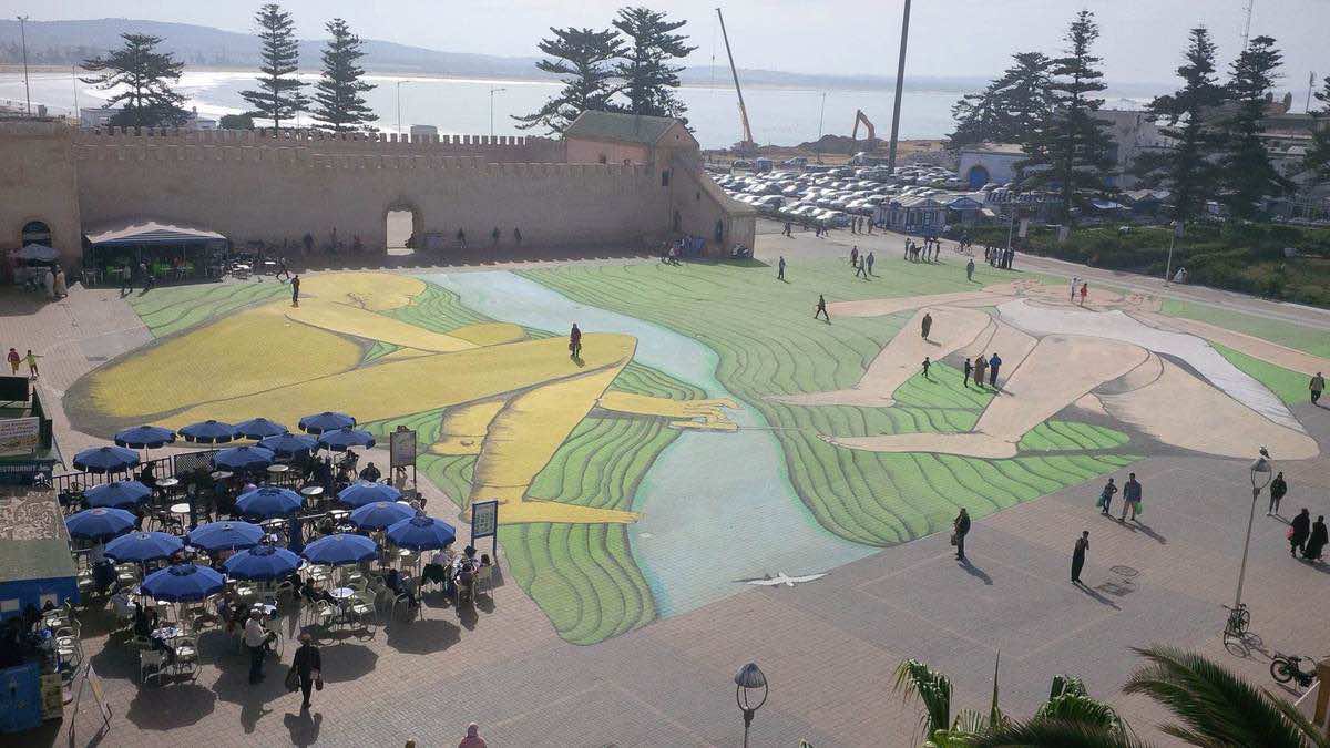 فنان إيطالي يرسم لوحة ضخمة على أرض ساحة في الصويرة