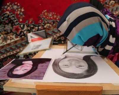 فتاة أفغانية معاقة تبدع في الرسم بفمها -صور وفيديو