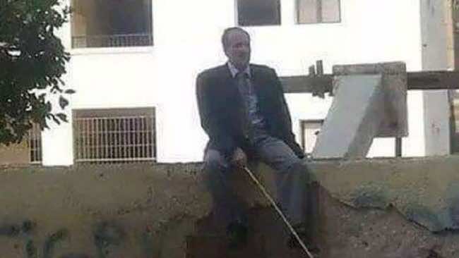 مدير مدرسة يجلس على السور بعصا لمنع التلاميذ من الهروب!