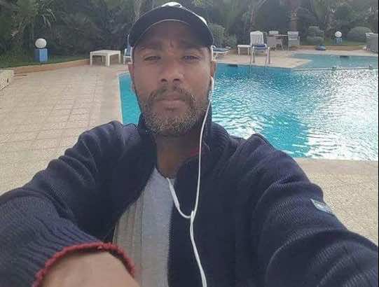 مصور أشرطة "القضاة والفساد" يضع لصاقا على فمه أثناء محاكمته