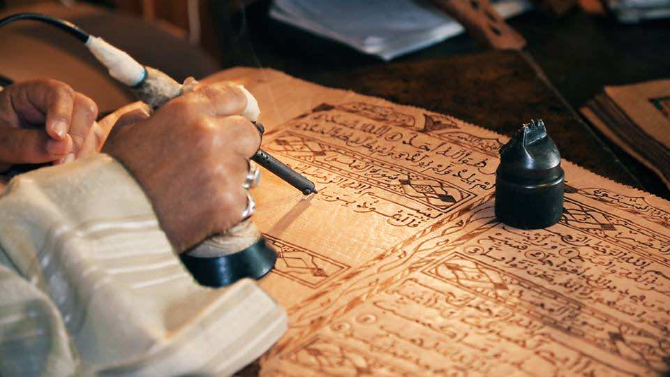 قصة "معاق" مغربي صنع "عكازه" بيده وكتب القرآن بـ"المكواة"-فيديو