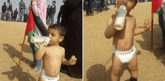 طفل فلسطيني يخلق الحدث في "مسيرة العودة".. رضاعة في يد وحجر في الأخرى - صورة