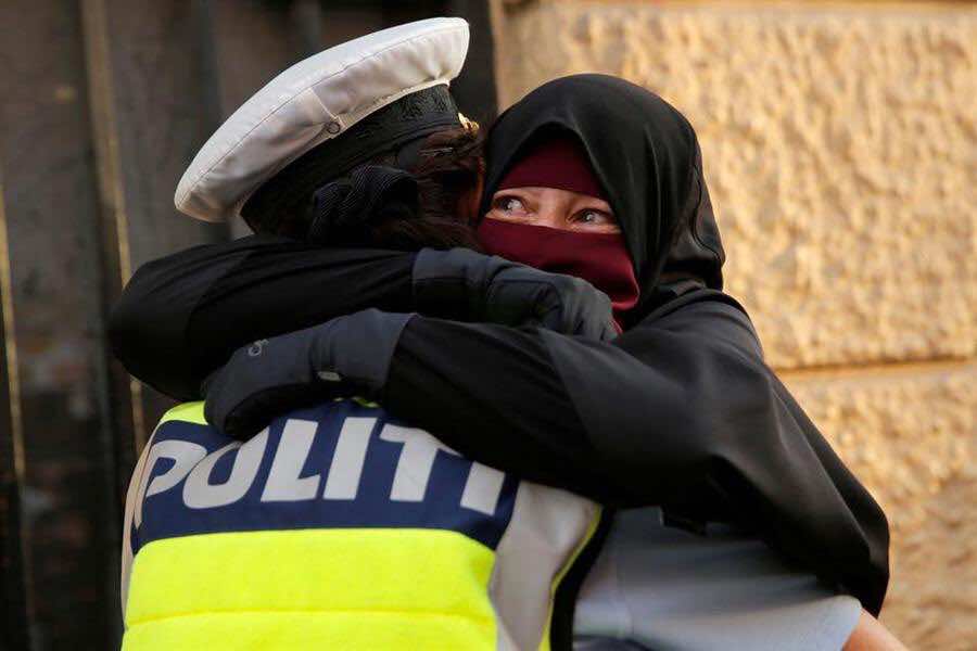 صورة شرطية دنماركية تحتضن مسلمة تظاهرت ضد قرار حظر النقاب تغزو الفايسبوك.. هذه قصتها